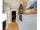 Hallway view showing hardwood floors, accent lighting, and a series of framed photos on a light blue wall at 1537 Harts Mill Ne Rd, Brookhaven, GA 30319