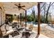 Covered patio with stylish outdoor seating, ceiling fan, and a view of the beautiful pool and backyard at 1537 Harts Mill Ne Rd, Brookhaven, GA 30319