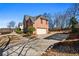 Side view of brick home with a two-car garage and long driveway at 3840 Montvale Xing, Cumming, GA 30041