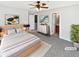 Stylishly staged main bedroom with gray carpet, ceiling fan, walk-in closet and ensuite bathroom at 1100 Cotton Gin Dr, Woodstock, GA 30188