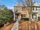 Charming brick townhome featuring dormer windows and landscaped front yard under a clear blue sky at 1100 Cotton Gin Dr, Woodstock, GA 30188