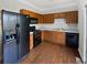 Functional kitchen with a black refrigerator and stove, and plenty of cabinet and countertop space at 1100 Cotton Gin Dr, Woodstock, GA 30188