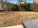 Large backyard with mature trees and a wooden deck at 213 Ermines Way, Mcdonough, GA 30253