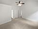 Empty bedroom with neutral carpet, ceiling fan, and multiple doors, providing versatility at 213 Ermines Way, Mcdonough, GA 30253