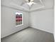 Bright, carpeted bedroom with a tray ceiling and a window that provides natural light at 213 Ermines Way, Mcdonough, GA 30253