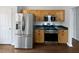 Kitchen featuring stainless steel appliances, light wood cabinets, and dark countertops at 213 Ermines Way, Mcdonough, GA 30253