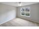 Well-lit bedroom with neutral walls, plush carpeting, and a bright window view at 2545 Lakemeadow Ln, Grayson, GA 30017