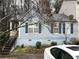 Charming home featuring a blue exterior, complemented by black shutters and a well-maintained front yard at 2041 Marbut Trce, Lithonia, GA 30058