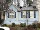 View of the home's exterior, highlighted by blue siding, black shutters, and meticulous landscaping at 2041 Marbut Trce, Lithonia, GA 30058