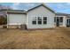 Back exterior featuring a screened porch, three windows, and the home's air conditioning unit at 2976 Rambler Dr, Loganville, GA 30052