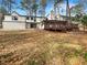 Expansive backyard featuring a wooden deck, mature trees, and privacy at 7040 Northgreen Dr, Atlanta, GA 30328