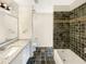 Well-lit bathroom with modern fixtures, a tiled shower/tub combination, and a granite countertop at 7040 Northgreen Dr, Atlanta, GA 30328