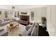 Bright living room with a brick fireplace, hardwood floors, and a sunroom offering ample natural light and cozy comfort at 7040 Northgreen Dr, Atlanta, GA 30328