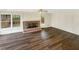 Cozy living room featuring a brick fireplace, ceiling fan, hardwood floors, and lots of light at 7040 Northgreen Dr, Atlanta, GA 30328