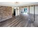Open concept living room with brick accent wall, hardwood floors and bright light at 7040 Northgreen Dr, Atlanta, GA 30328