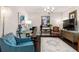 Elegant living room featuring a glass desk, stylish blue sofa and chairs, and decorative lighting at 206 William Creek Dr, Canton, GA 30115