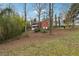 Charming red home with a double porch, nestled on a large lot with mature trees and partial grass at 605 Jeffrey Ct, Woodstock, GA 30188