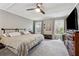 Main bedroom with large bed, hard wood furniture, a ceiling fan, and well-lit windows at 605 Jeffrey Ct, Woodstock, GA 30188