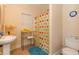 Bright bathroom featuring cheerful, colorful shower curtain and sleek fixtures at 2875 Ivy Brook Ln, Buford, GA 30519
