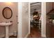 Hallway bathroom with a pedestal sink and doorway to a dining room with an ornate light fixture at 2875 Ivy Brook Ln, Buford, GA 30519