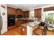 Bright eat-in kitchen featuring hardwood floors, granite countertops, and custom wooden cabinets with stainless appliances at 2875 Ivy Brook Ln, Buford, GA 30519