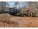 View of backyard and the home with unique treehouse structure, surrounded by bare trees at 3894 Foxford Dr, Atlanta, GA 30340