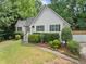 View of home with manicured landscaping, a stone accent, and a well-maintained lawn at 7115 Shady Oak Ln, Cumming, GA 30040