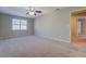 Spacious carpeted bedroom with a ceiling fan and a bright window for natural light at 169 Holly Ct, Loganville, GA 30052