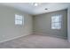 Carpeted bedroom with two large windows offering plenty of natural light at 169 Holly Ct, Loganville, GA 30052