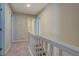 Hallway with neutral walls and trim featuring a railing and carpeted floor at 169 Holly Ct, Loganville, GA 30052