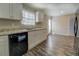 Bright kitchen with granite countertops, white cabinetry, and modern black appliances at 169 Holly Ct, Loganville, GA 30052