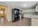 Well-lit kitchen featuring white cabinetry, modern appliances, and wood-look flooring at 169 Holly Ct, Loganville, GA 30052