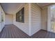 Covered front porch with wood flooring and white railings perfect for relaxing outdoors at 169 Holly Ct, Loganville, GA 30052