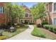 Inviting exterior with lovely landscaping, flowers and a sidewalk leading to a warmly colored condo building at 5300 Brooke Ridge Dr, Dunwoody, GA 30338