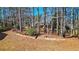 Spacious backyard features trees, a zipline, and a retaining wall with garden bed at 672 Red Sunset Cir, Powder Springs, GA 30127