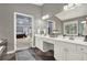 Bright bathroom with double sinks, white cabinets, stone tile floors, and open entry to bedroom at 672 Red Sunset Cir, Powder Springs, GA 30127