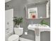 Charming bathroom with a pedestal sink, framed mirror, and tiled flooring at 672 Red Sunset Cir, Powder Springs, GA 30127