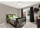 Bedroom with a gray wall, a bed, a ceiling fan and a window with black curtains at 672 Red Sunset Cir, Powder Springs, GA 30127