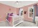 Cozy bedroom with white bed frame, colorful decor, and natural light from two windows at 672 Red Sunset Cir, Powder Springs, GA 30127