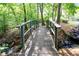 Charming wooden bridge surrounded by lush foliage crossing a stream at 672 Red Sunset Cir, Powder Springs, GA 30127