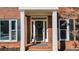 Inviting front entrance with decorative columns and a classic black door at 672 Red Sunset Cir, Powder Springs, GA 30127