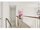 Hallway view with wood and white banister leading to a bedroom with bright pink walls at 672 Red Sunset Cir, Powder Springs, GA 30127