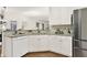 Well-lit kitchen featuring a breakfast bar, white cabinetry, and stainless steel refrigerator at 672 Red Sunset Cir, Powder Springs, GA 30127
