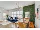 Open-concept living area with blue sofa, dining set, stylish lighting, and leafy green wall for a unique modern design at 680 Greenwood Ne Ave # 202, Atlanta, GA 30306