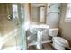 This full bathroom features a pedestal sink, toilet, glass shelving, and a glass enclosed shower at 940 Highview Se Dr, Smyrna, GA 30082