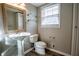 This bathroom features a pedestal sink, modern toilet, glass shelves, and a window at 940 Highview Se Dr, Smyrna, GA 30082