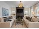 An elegant living room featuring a fireplace, neutral-toned sofas, and large windows at 1004 Baldwin Dr, Milton, GA 30009