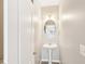 A pedestal sink with oval mirror is featured in the half bath at 2414 Clock Face Ct, Lawrenceville, GA 30043