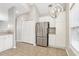 Bright kitchen features stainless steel refrigerator, white cabinetry, and modern light fixture at 2414 Clock Face Ct, Lawrenceville, GA 30043