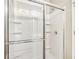White tiled shower with glass enclosure and integrated shelves at 2414 Clock Face Ct, Lawrenceville, GA 30043